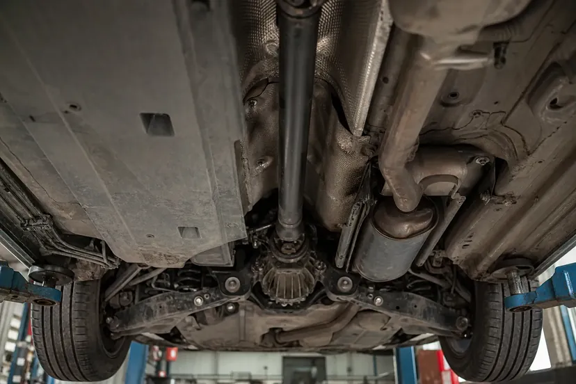 Dessous de caisse d'un SUV sur pont élévateur : arbre de transmission longitudinal, différentiel arrière et cardans