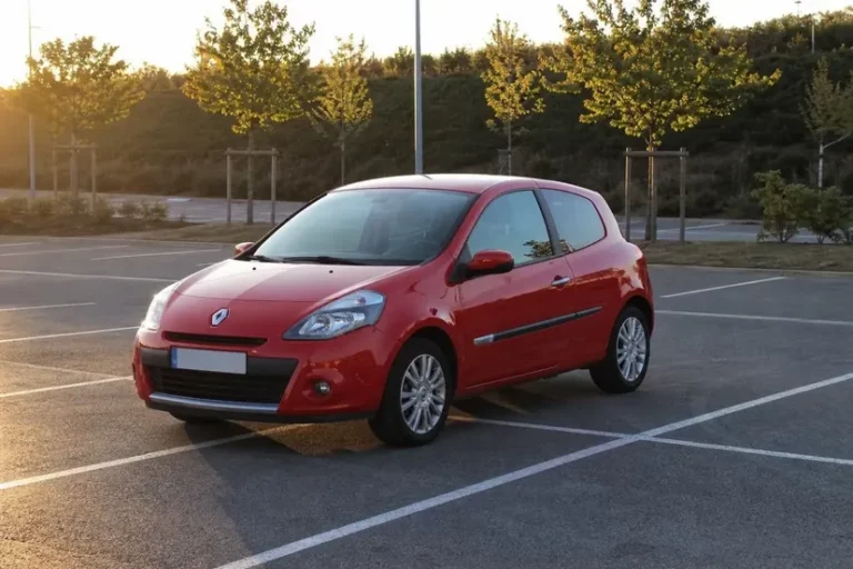 Renault Clio 3 phase 2 rouge garée seule sur un parking désert en fin de journée, capot fermé