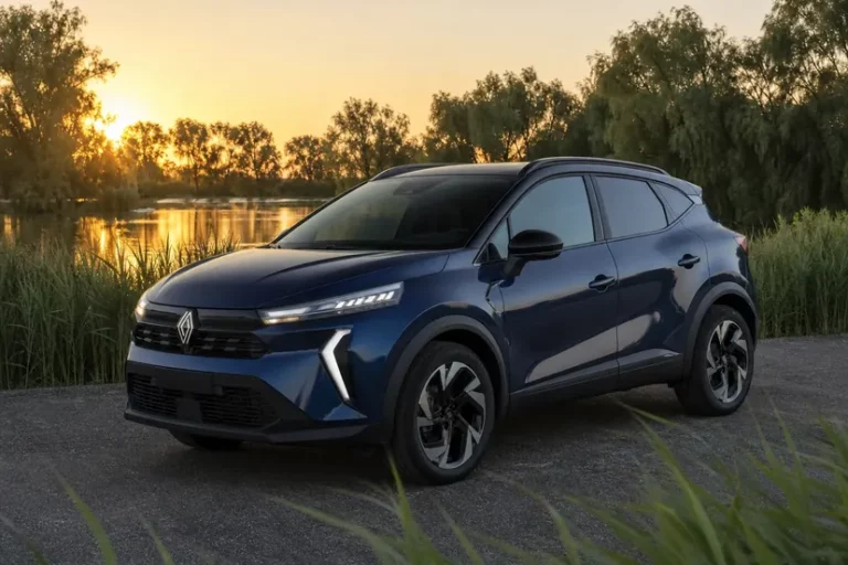 Un Renault Captur bleu nocturne à toit noir, vu de trois quarts avant, garé seul sur une esplanade au bord d'un étang en fin de journée.